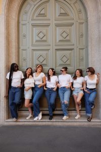 Une groupe de femmes diverses posant devant une grande porte en pierre à Odessa.