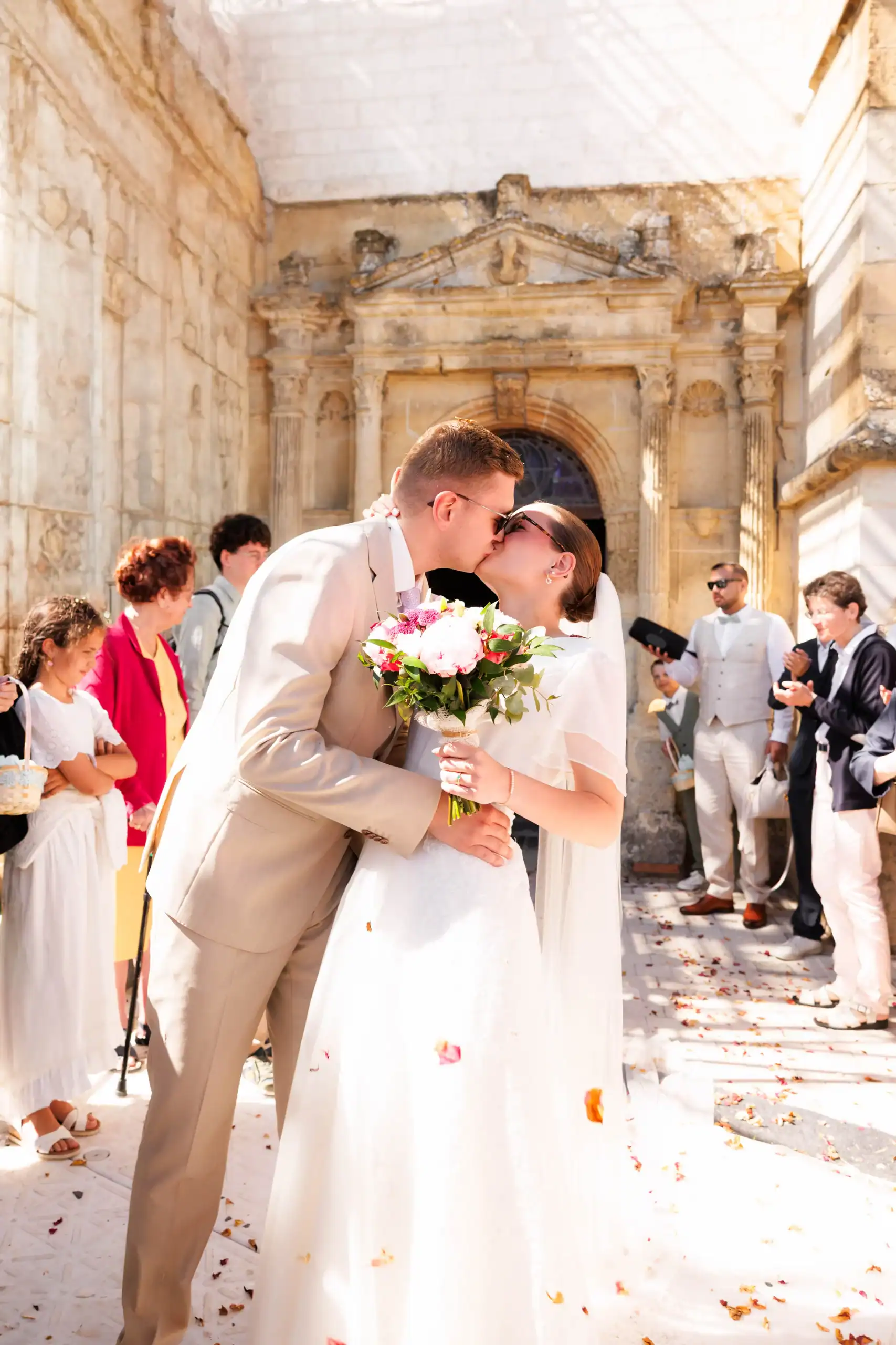 Jeune couple de mariés s'embrassant devant une vieille architecture à Odessa.